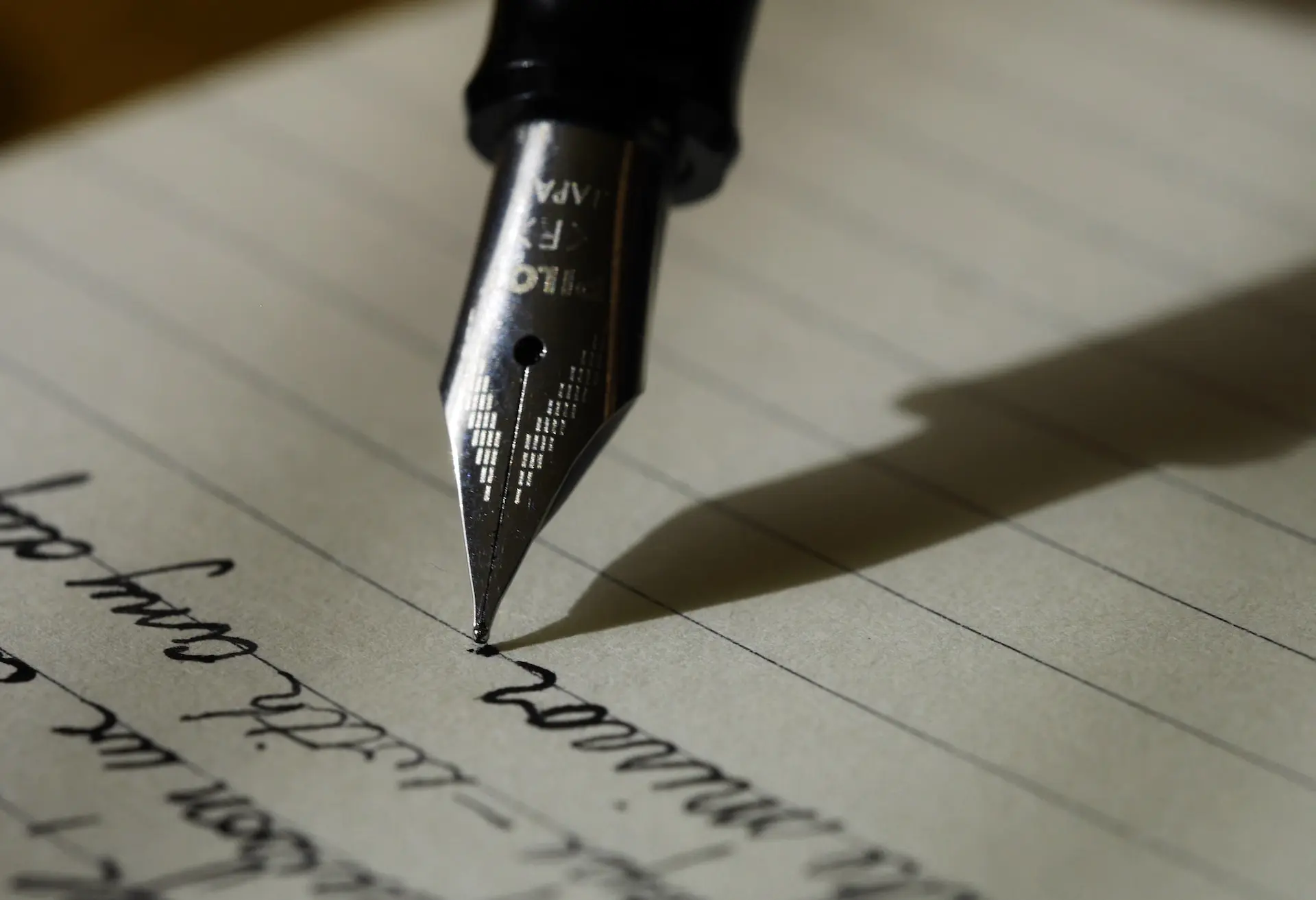 fountain pen on black lined paper